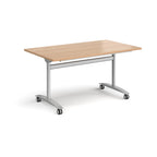 Rectangular table with a wood-effect top and silver metal legs with castors on a white background