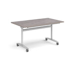 Rectangular table with a grey wood-effect top and silver metal legs with castors on a white background