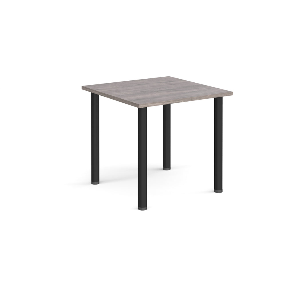 Square table with grey wood-effect top and black legs on a white background