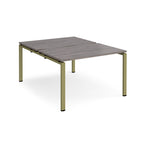 Back-to-back desk with grey wood-effect top and green metal frame on a white background