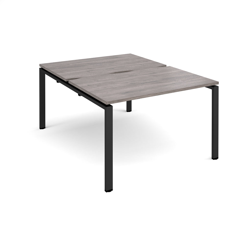 Back-to-back desk with grey wood-effect top and black metal frame on a white background