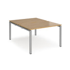 Back-to-back desk with wood-effect top and silver metal frame on a white background