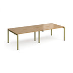Four back-to-back desks with wood-effect tops and green metal frame on a white background