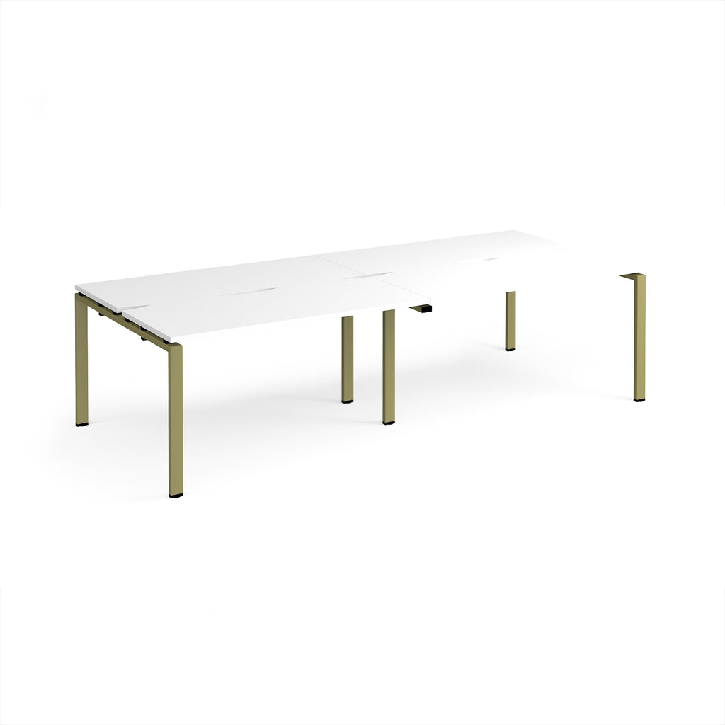Four back-to-back desks with white tops and green metal frame on a white background