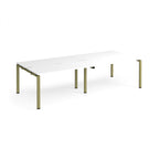 Four back-to-back desks with white tops and green metal frame on a white background