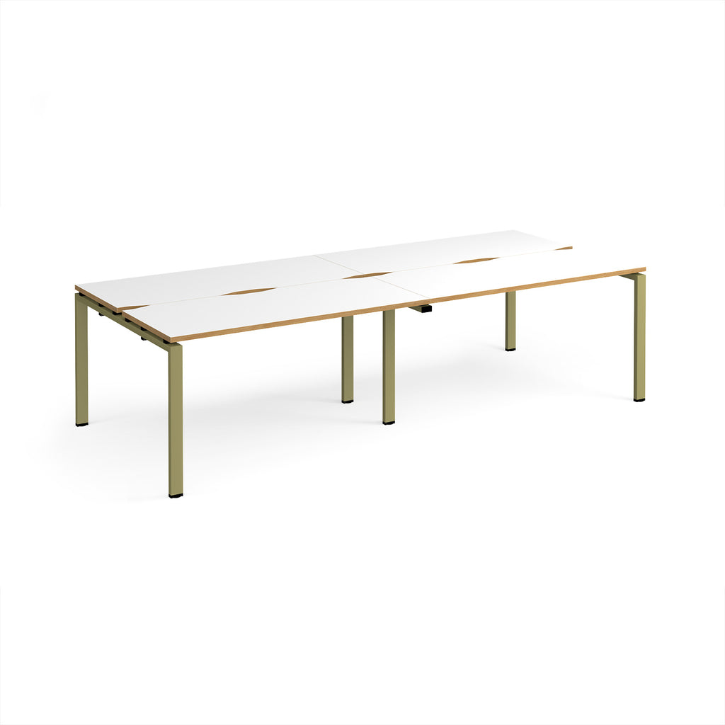 Four back-to-back desks with white tops with wooden edges and green metal frame on a white background
