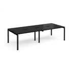Four black back-to-back desks with metal frame on a white background