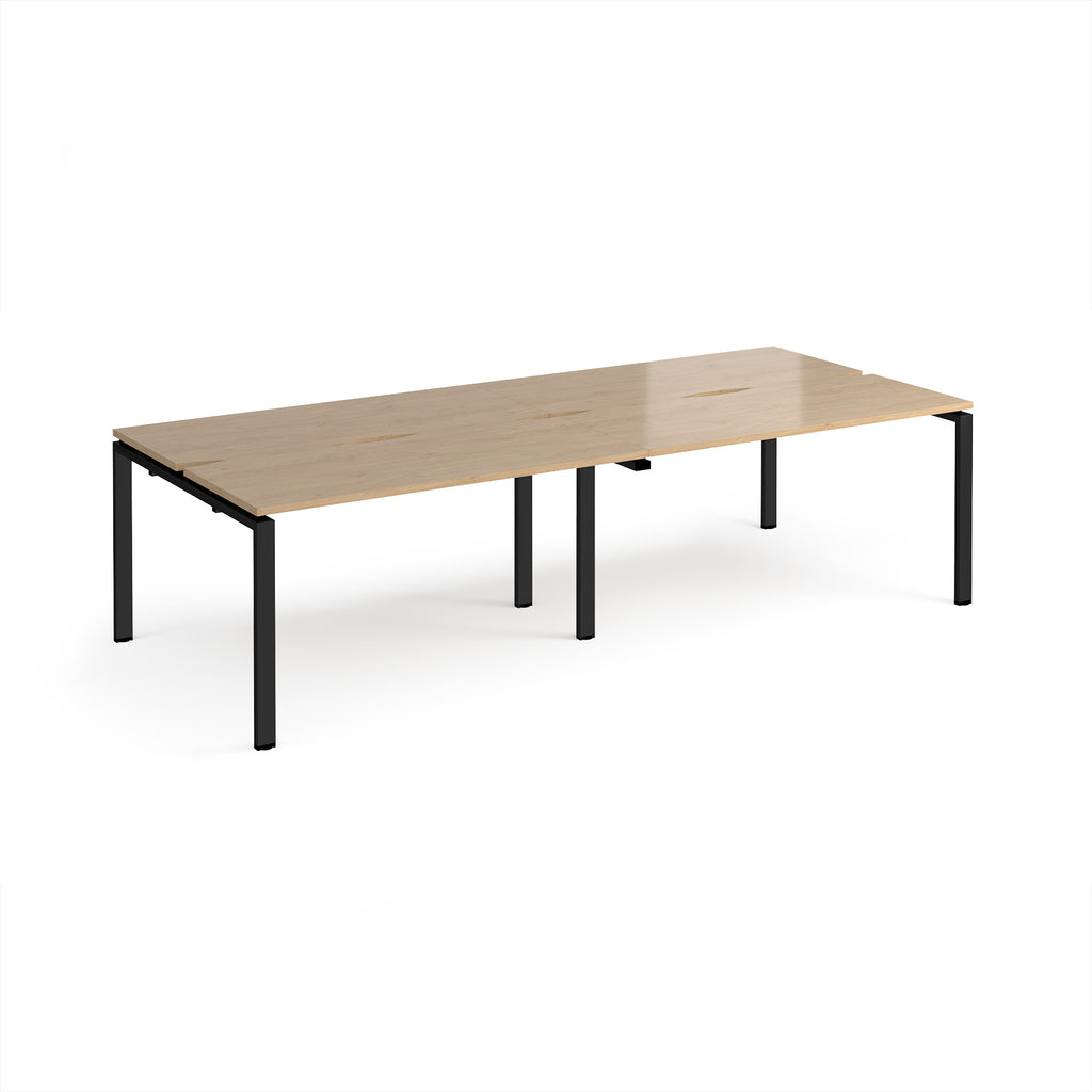 Four back-to-back desks with wood-effect tops and black metal frame on a white background