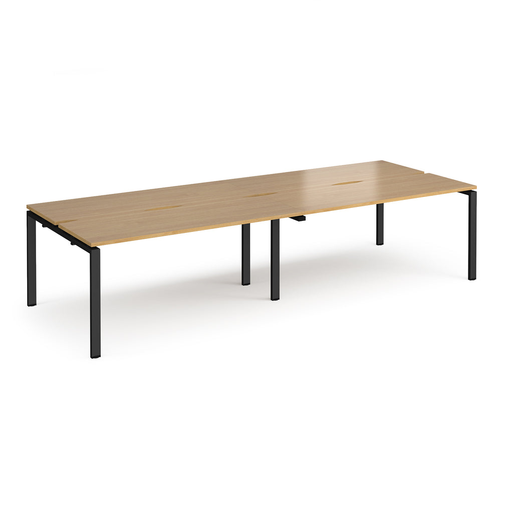Four back-to-back desks with wood-effect tops and black metal frame on a white background
