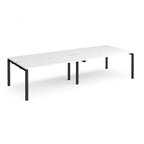 Four back-to-back desks with white tops and black metal frame on a white background