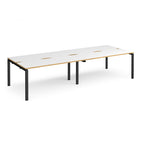 Four back-to-back desks with white tops with wooden edges and black metal frame on a white background