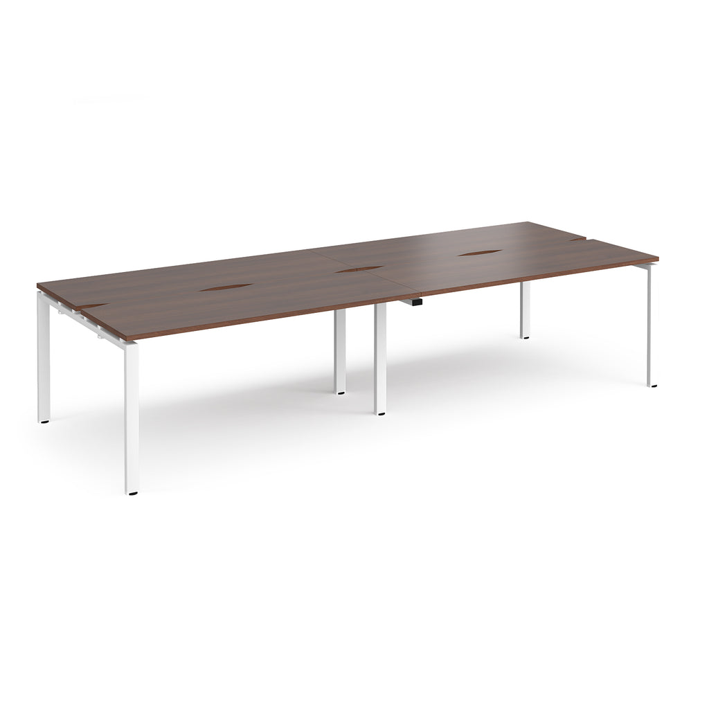 Four back-to-back desks with wood-effect tops and white metal frame on a white background