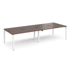Four back-to-back desks with wood-effect tops and white metal frame on a white background