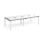 Four back-to-back desks with white tops with black edges and white metal frame on a white background