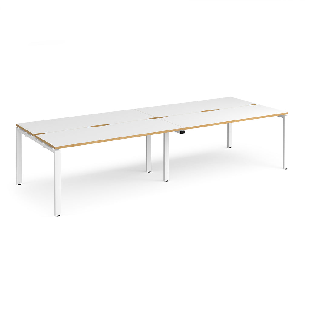 Four back-to-back desks with white tops with wooden edges and white metal frame on a white background