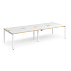 Four back-to-back desks with white tops with wooden edges and white metal frame on a white background