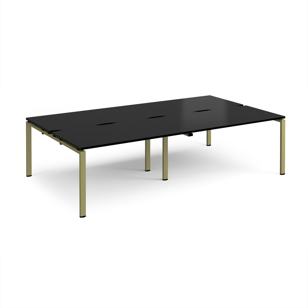 Four back-to-back desks with black tops and green metal frame on a white background