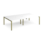 Four back-to-back desks with white tops and green metal frame on a white background