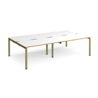 Four back-to-back desks with white tops with wooden edges and green metal frame on a white background
