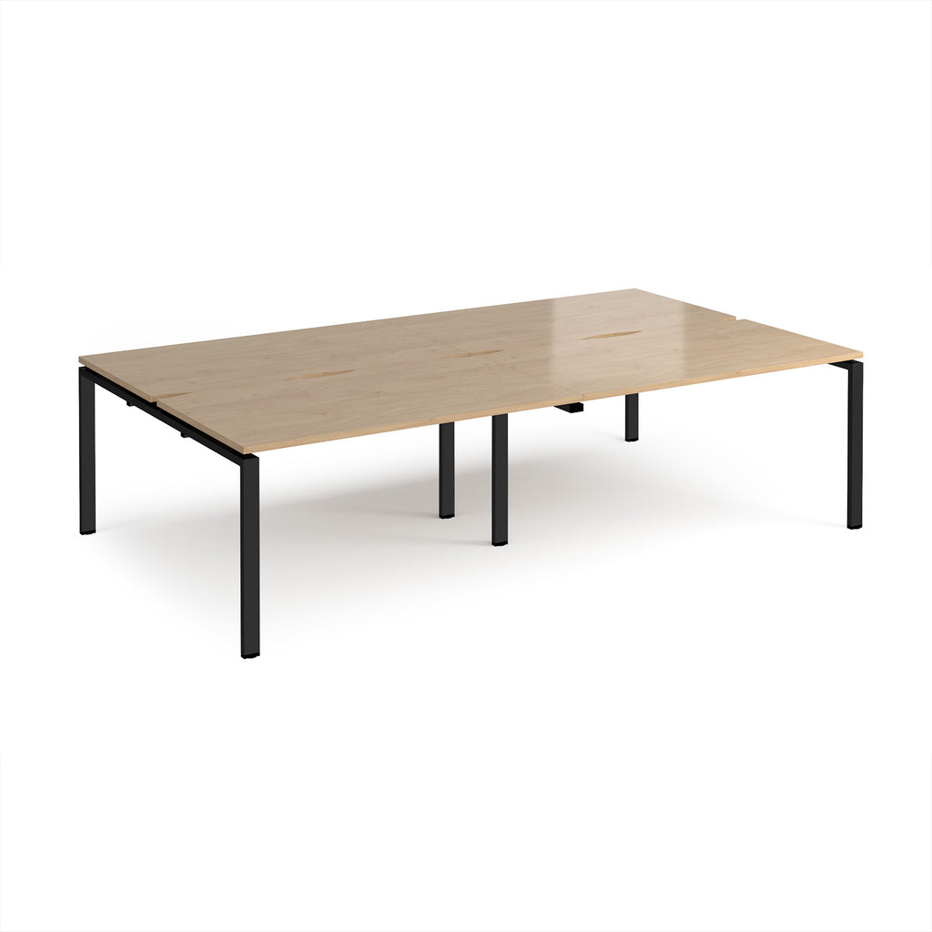 Four back-to-back desks with wood-effect tops and black metal frame on a white background