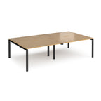 Four back-to-back desks with wood-effect tops and black metal frame on a white background