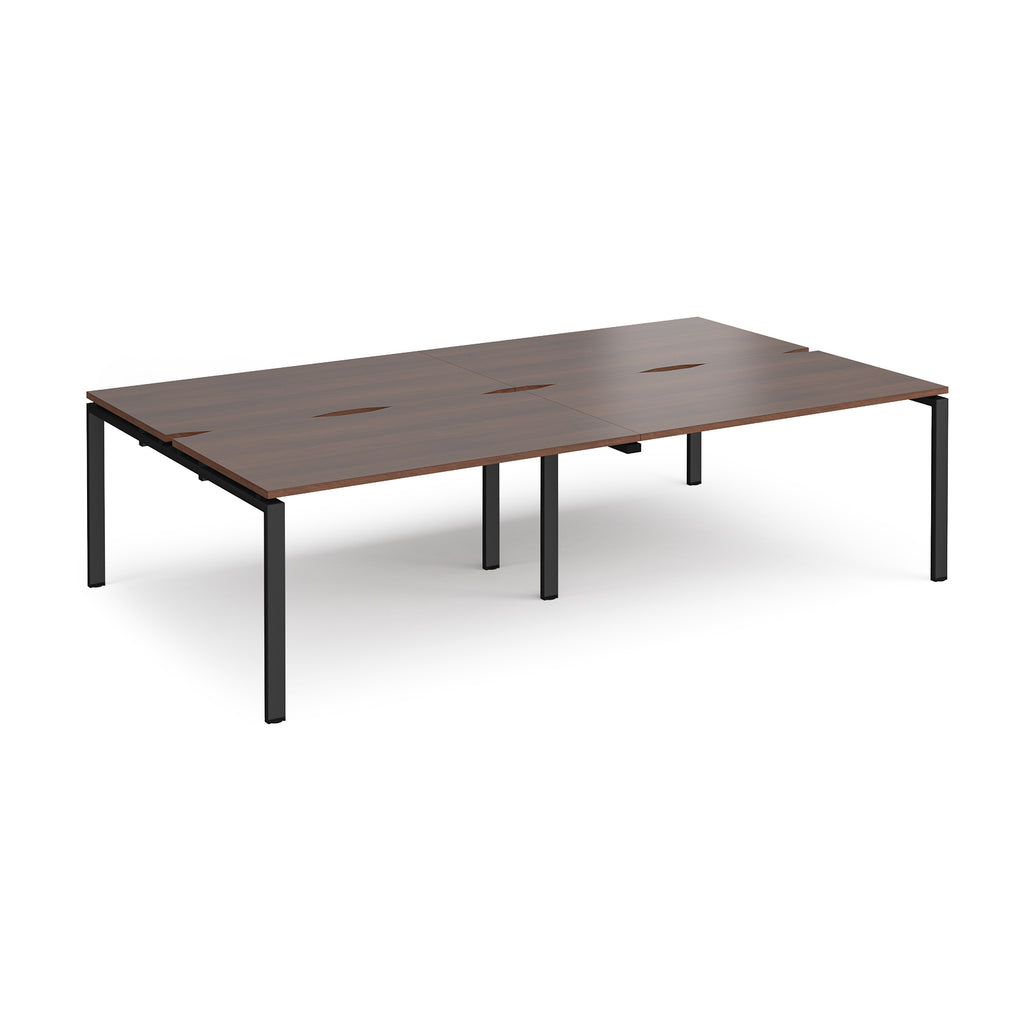 Four back-to-back desks with wood-effect tops and black metal frame on a white background