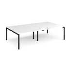 Four back-to-back desks with white tops and black metal frame on a white background