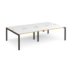 Four back-to-back desks with white tops with wooden edges and black metal frame on a white background