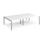 Four back-to-back desks with white tops and silver metal frame on a white background
