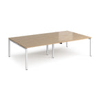 Four back-to-back desks with wood-effect tops and white metal frame on a white background