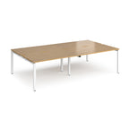 Four back-to-back desks with wood-effect tops and white metal frame on a white background