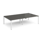 Four back-to-back desks with grey tops and white metal frame on a white background