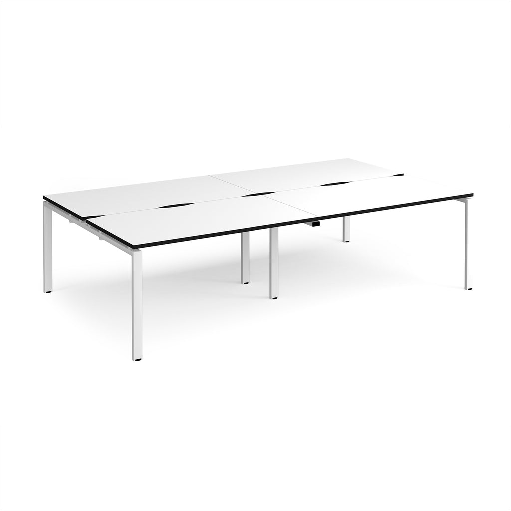 Four back-to-back desks with white tops with black edges and white metal frame on a white background