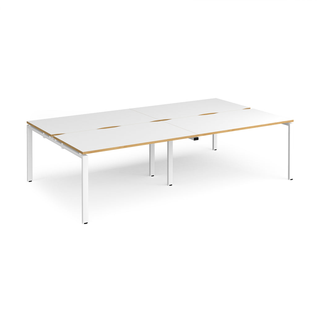 Four back-to-back desks with white tops with wooden edges and white metal frame on a white background