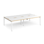 Four back-to-back desks with white tops with wooden edges and white metal frame on a white background
