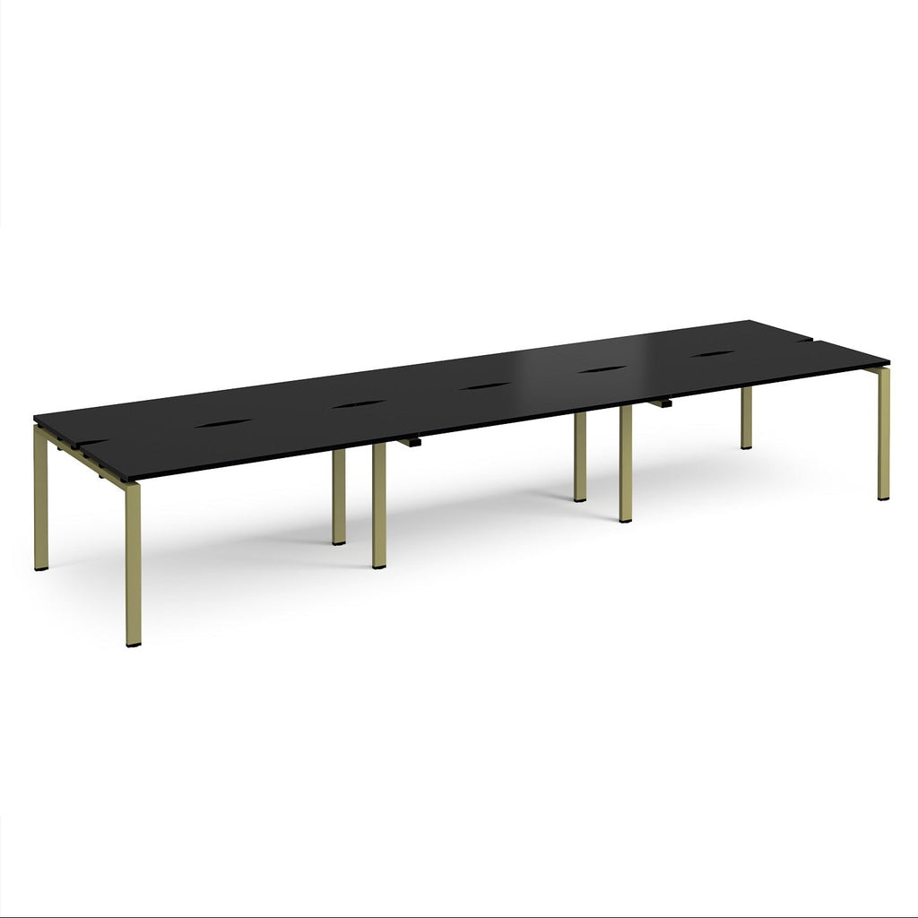 Long back-to-back desk with black top and green metal frame on a white background