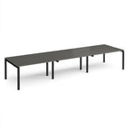Long back-to-back desk with grey top and black metal frame on a white background