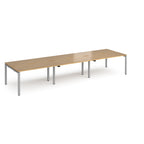 Long back-to-back desk with wood-effect top and silver metal frame on a white background