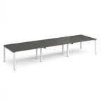 Long back-to-back desk with grey top and white metal frame on a white background