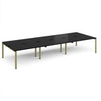 Long back-to-back desk with black top and green metal frame on a white background