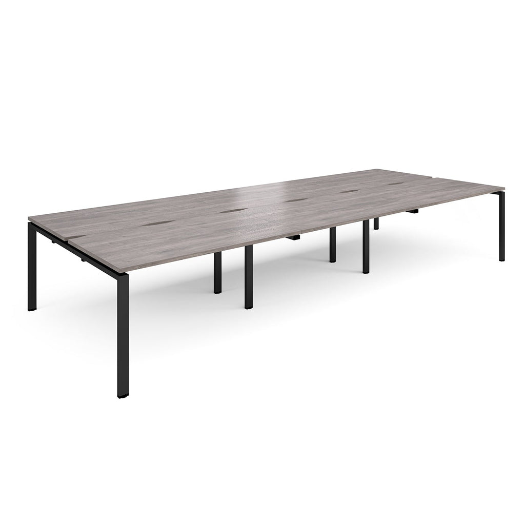 Long back-to-back desk with grey wood-effect top and black metal frame on a white background