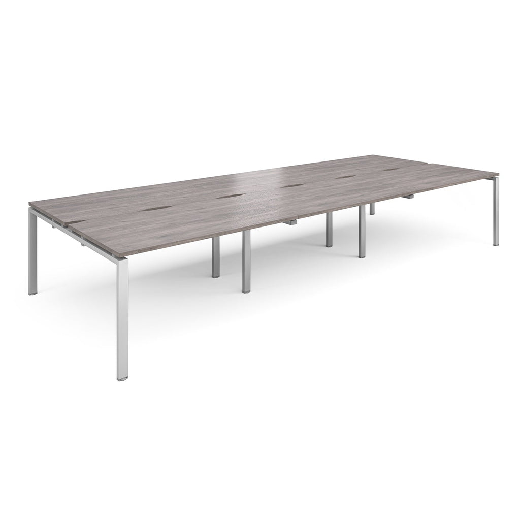 Long back-to-back desk with grey wood-effect top and silver metal frame on a white background