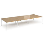 Long back-to-back desk with wood-effect top and white metal frame on a white background