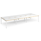 Long back-to-back desk with white top with wooden edges and green metal frame on a white background