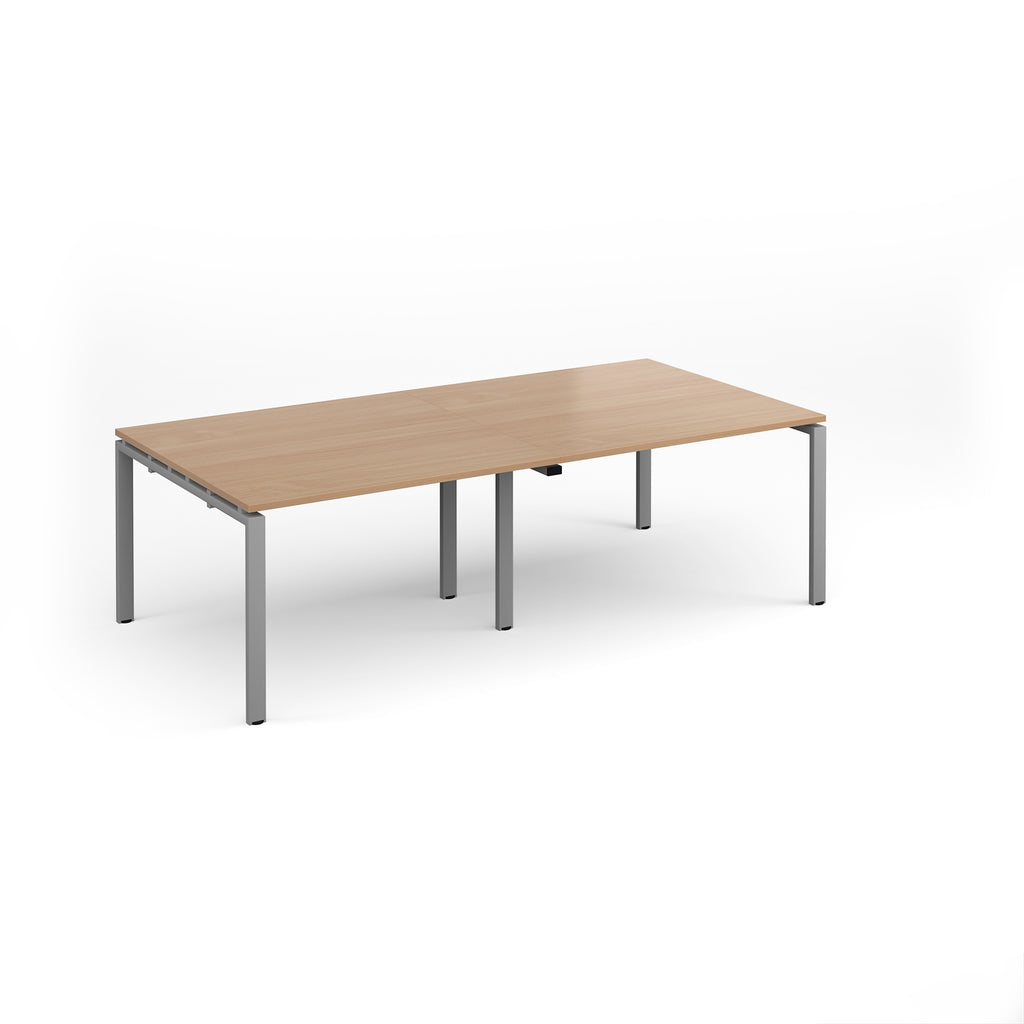 A rectangular office table with a light wood grain top and slim silver metal legs, shown on a clean white background.