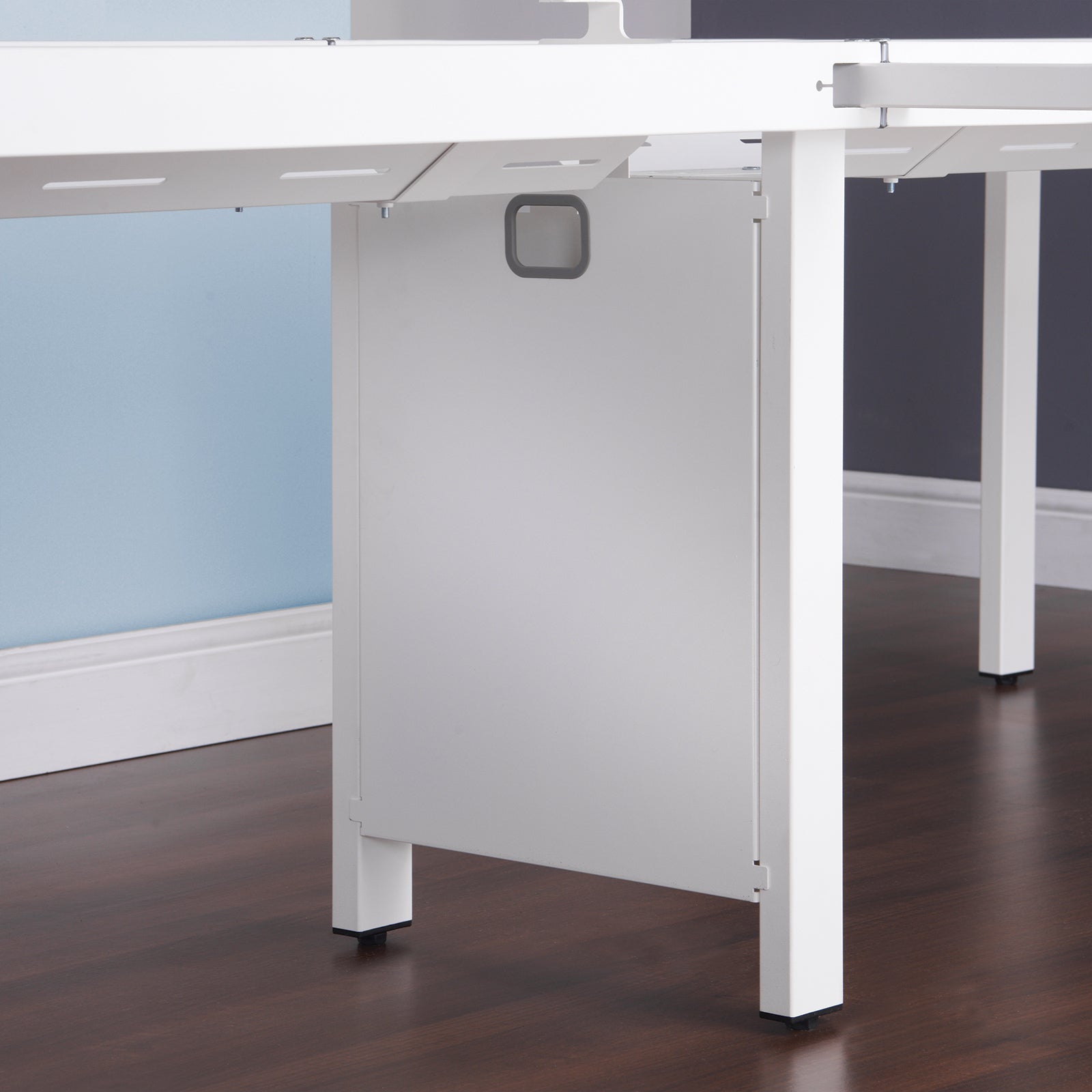 White office desk with a dark wood floor and light blue wall.