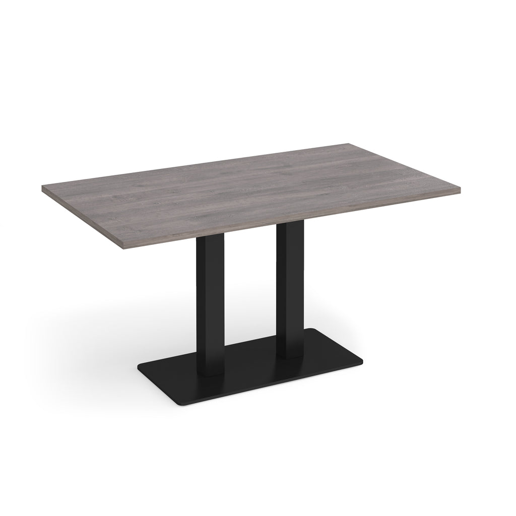 A rectangular dining table with a grey wood-grain top and a black metal pedestal base, shown on a plain white background.