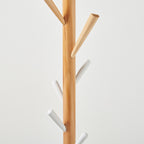 Wooden and white coat rack on a light grey background