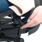Close-up of a hand adjusting a component on a stroller.