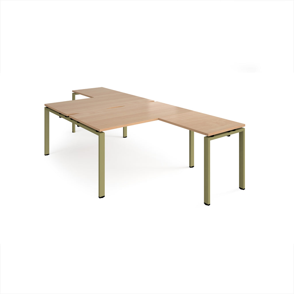 L-shaped back-to-back desks with wood-effect top and a green metal frame on a white background